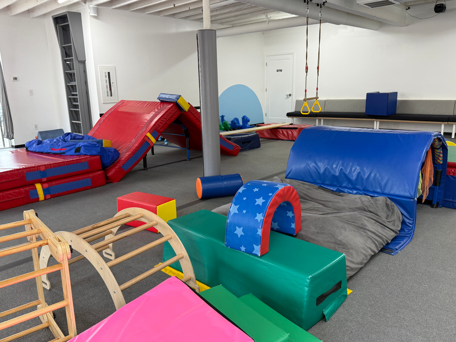 Open tumble setup at tumble HAUS Denver with soft arches, mats and a padded crawl tunnel